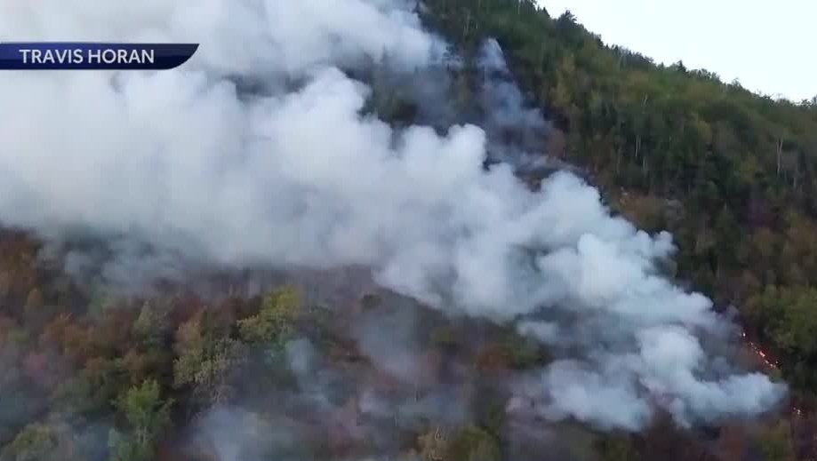 A Blackhawk helicopter is helping firefighters battle a forest fire in Woodstock that grew significantly overnight. The blaze, which is now being referred to as the Boulder Cave Fire, continued its march along Kinsman Ridge in Woodstock. It has burned about 25 acres